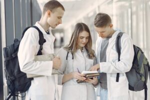 Medical students gather around a table reviewing materials and collaborating during a small group session.