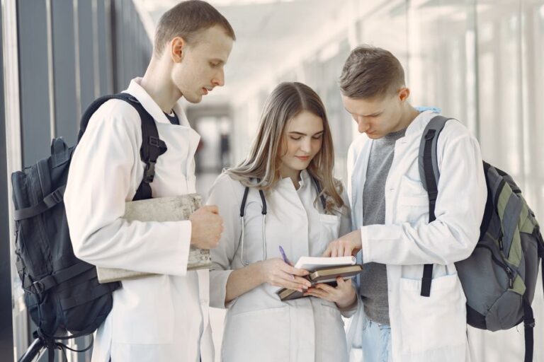 Medical students gather around a table reviewing materials and collaborating during a small group session.