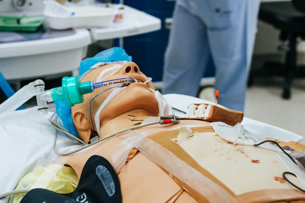 Medical students practice procedures together on a high-fidelity simulation mannequin in a classroom lab.