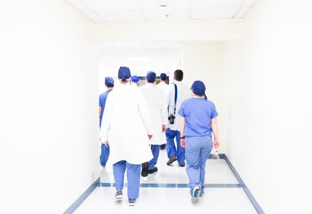 Medical students practicing clinical skills on a mannequin in a modern simulation lab.
