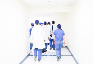 Medical students practicing clinical skills on a mannequin in a modern simulation lab.