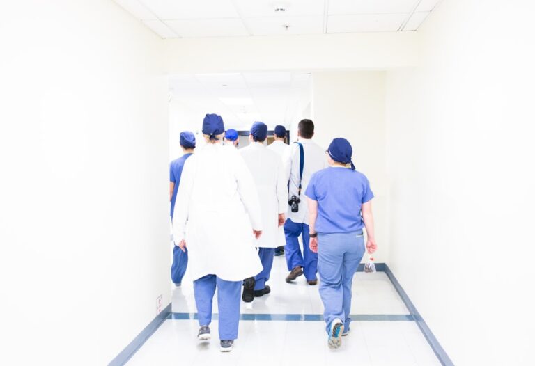 Medical students practicing clinical skills on a mannequin in a modern simulation lab.